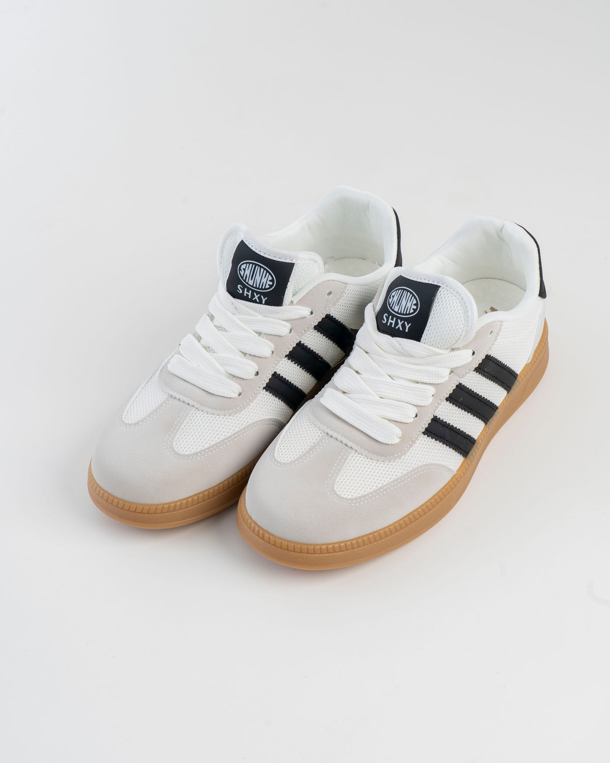 Pair of men's white sneakers with black side stripes and gum-style soles