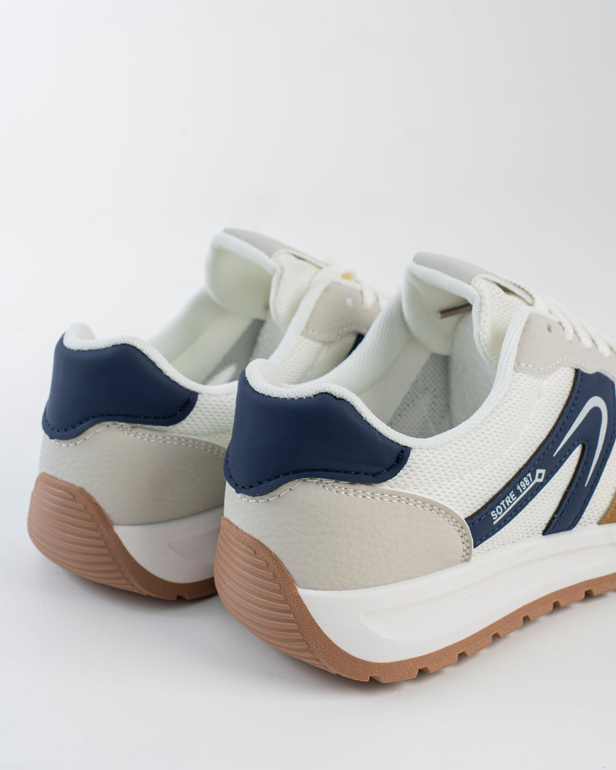 Off-white sneaker with navy side detail and gum-toned outsole