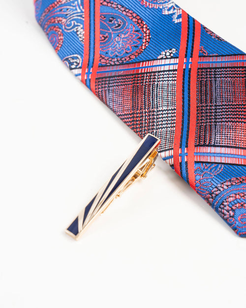 Black stripe gold-tone tie clip detail on a blue patterned tie