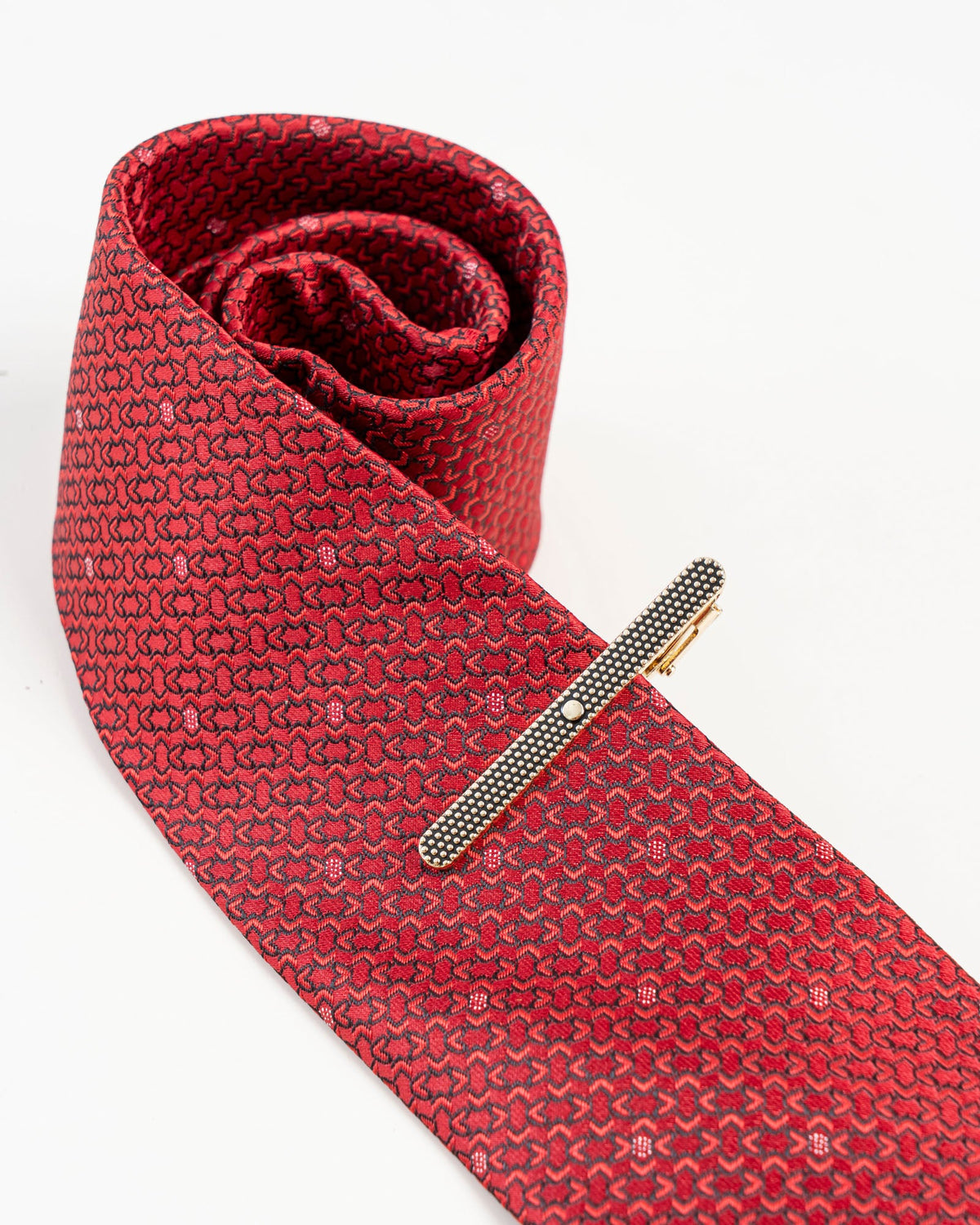 Black textured gold-tone tie clip isolated close-up