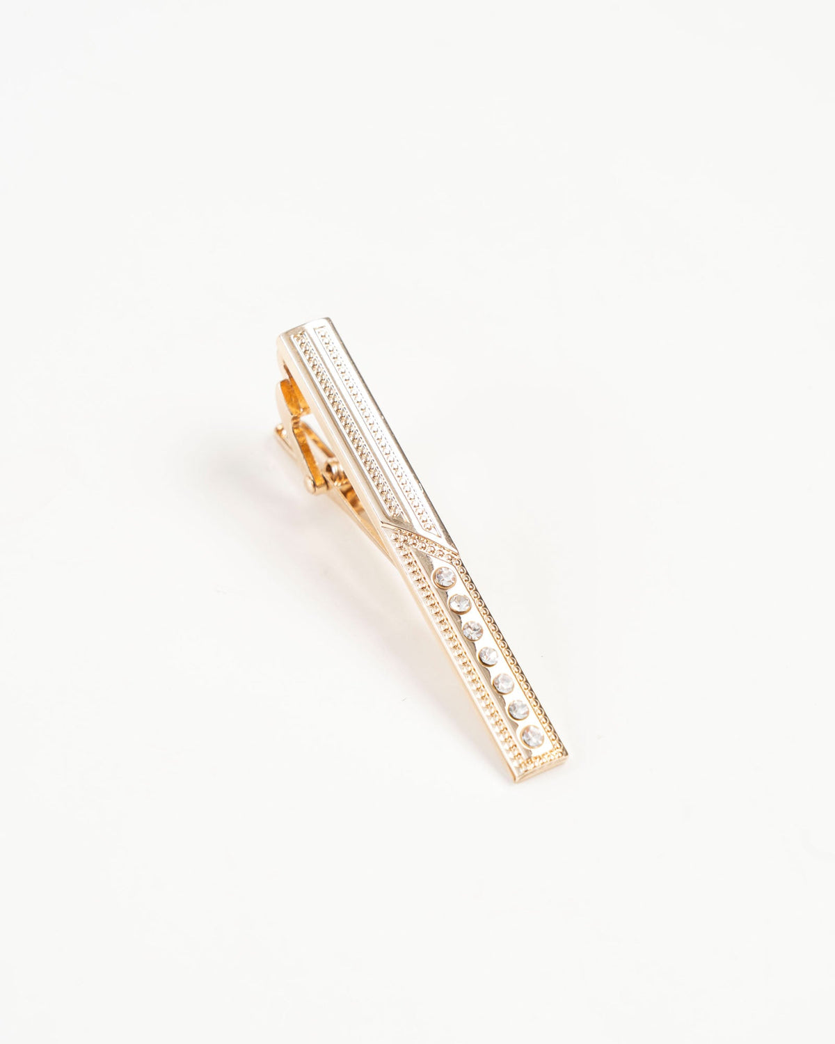Crystal accent gold-tone tie clip isolated close-up